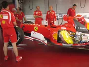 A formula one pit crew hovers around an F-1 car. This car is going through it's final check-up at the Ferrari Track before it races the following weekend. A formula one pit crew hovers around an F-1 car. This car is going through it's final check-up at the Ferrari Track before it races the following weekend.