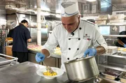 Chefkoch Henere Adams (re.) bereitet eines der traditionellen Gerichte Franz&ouml;sisch-Polynesiens zu: in Kokosmilch gegartes Ziegenfleisch.