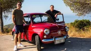 Elvis on right side of red Seat 600, Mike on right by open front door of car, sea in background Elvis on right side of red Seat 600, Mike on right by open front door of car, sea in background
