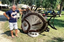 K&uuml;nstler auf Italiens malerischer Mittelmeerinsel: Luca Polesi neben seinem Kunstwerk "Il Pesce".