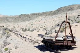 Alte Eisenbahnschienen mit einem verrosteten Schienenfahrzeug.