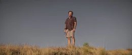 Samet (Deniz Celiloğlu) auf einer trockenen Wiese.