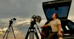 Warten auf den richtigen Blitz: Dem Filmer schafft der offene Kofferraum wenigstens einen kleinen Schutz gegen den Regen, dennoch sitzt er beim Gewittersturm immer auf dem Pr&auml;sentierteller.