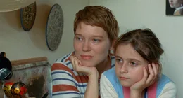 Sandra (L&eacute;a Seydoux ) sitzt am K&uuml;chentisch mit Tochter Linn (Camille Leban-Martins) auf dem Scho&szlig;.