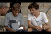 George (Mi.) zeigt Olivier (li.) und Corentin de Chatelperron (re.), wie er aus weggeworfenen Batterien Strom bezieht. Oft reichen wenige Batterien aus, um damit Lampen für ein ganzes Haus zu betreiben. George (Mi.) zeigt Olivier (li.) und Corentin de Chatelperron (re.), wie er aus weggeworfenen Batterien Strom bezieht. Oft reichen wenige Batterien aus, um damit Lampen für ein ganzes Haus zu betreiben.