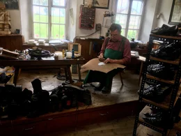Viel zu tun hat der Schuster Johann Stehb&ouml;ck aus Ainring mit dem Besohlen der Haferlschuhe der Plattler und  den Schuhen ihrer Tanzpartnerinnen.