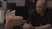 A police officer wearing looks at notes.
