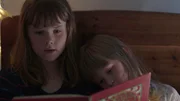 Agnes (li., Synne Asplund) l&auml;sst Elsa (re., Maya Anna Hansen Fr&oslash;lich) in ihr Bett und gemeinsam lesen sie noch.