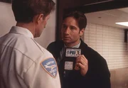 Am Flughafen wird Mulder (David Duchovny) von einem Sicherheitsbeamten überprüft ... Am Flughafen wird Mulder (David Duchovny) von einem Sicherheitsbeamten überprüft ...