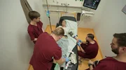 Berlin: three members of staff are standing, another one kneeling around a female patient. One of the nurses is at her feet, while the other is checking her hand probably prior to extract some blood. Berlin: three members of staff are standing, another one kneeling around a female patient. One of the nurses is at her feet, while the other is checking her hand probably prior to extract some blood.