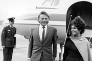 Der walisische Schauspieler Richard Burton (Mi., 1925&ndash;1984) und seine Frau, die britische Schauspielerin Elizabeth Taylor (re.), steigen am 14. Oktober 1968 aus ihrem Privatflugzeug aus.