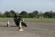 Mark Van Driel drives a motorbike around a corner at speed showing centripetal force. Mark Van Driel drives a motorbike around a corner at speed showing centripetal force.