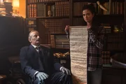 Marcos (Pavlos Kourtidis) erklärt mit Hilfe seiner Enkelin Hekate (Sofia Koliofotos), warum die Familie Rembetis gegenüber dem Flötenspiel des Pan (Aslan Aslan) immun ist. Marcos (Pavlos Kourtidis) erklärt mit Hilfe seiner Enkelin Hekate (Sofia Koliofotos), warum die Familie Rembetis gegenüber dem Flötenspiel des Pan (Aslan Aslan) immun ist.