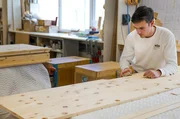 Kleiderschrank aus Zirbenholz: Schreiner Julius Lux beim Feinschliff f&uuml;r die T&uuml;rgriffeinsparung des Kleiderschranks in der Schreinerei Kopf in Stuttgart