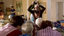 Johanna Schreier (Mareike Beykirch) fotografiert eine Gruppe Senioren.