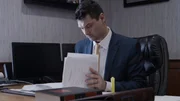 Contributor Clayton Crates, Judith Hawkey's Defense Attorney, sat at this desk looking through paperwork, with a book and folder on the desk in the foreground. Interior, landscape