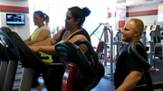 Bettie Jo working out in a gym with a personal trainer.