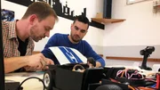 Norman (l.) is working on a Ford Mustang Shelby GT 350 while Johannes Perly watches him. Norman (l.) is working on a Ford Mustang Shelby GT 350 while Johannes Perly watches him.
