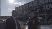 Demery and a cop talk in front a of rundown building. Demery and a cop talk in front a of rundown building.