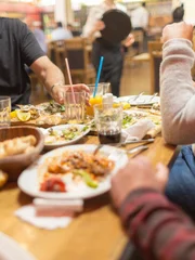 Group of Arab people in restaurant enjoying Middle Eastern Iftar food. Selective focus