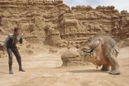 Nachdem Jason (Tim Allen, l.) von seiner Crew zur&uuml;ckgelassen wurde, wird er von einem seltsam anmutenden Wesen geweckt. Diese Mischung aus Dinosaurier und Schwein soll  nun - von den Einheimischen angestachelt - gegen Jason k&auml;mpfen. Wird er den Zweikampf f&uuml;r sich entscheiden?