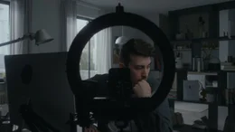 Aaron (Kai Bosse) sitzt am Schreibtisch und denkt &uuml;ber einen guten Einstieg f&uuml;r sein neues Video auf seinem Kanal nach.