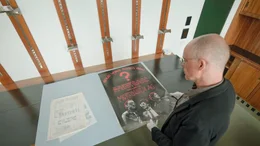 Wien-Museum Kurator Peter Stuiber mit einem Plakat der Mordsbuben AG.