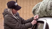 Nana schn&uuml;rt den Baum auf das Autodach