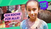 Basma steht im geschmückten Garten. Sie hat ihr großes Nachbarschaftsessen vorbereitet und freut sich auf das Fest Basma steht im geschmückten Garten. Sie hat ihr großes Nachbarschaftsessen vorbereitet und freut sich auf das Fest