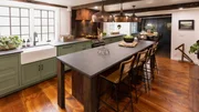 An after photo of the kitchen with the dining room visible in the background, as seen on Farmhouse Fixer, Season 3.