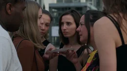 Lea (B&auml;rbel Schwarz) dr&auml;ngt Menschen auf der Stra&szlig;e dazu sich ihrer Gruppe von Verschw&ouml;rungstheoretiker:innen anzuschlie&szlig;en.