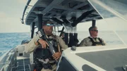 Die Marineeinheit ist auf Patrouille, um nach kriminellen Aktivit&auml;ten Ausschau zu halten; einer von ihnen h&auml;lt eine Waffe in der Hand. (Stampede Productions)
