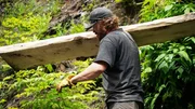 Scott Allen trägt eine Holzplanke. Scott Allen trägt eine Holzplanke.