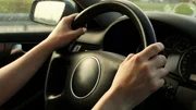 Woman driving car, only seeing her hands holding steering wheel. Woman driving car, only seeing her hands holding steering wheel.