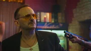 Andi Knuppe (Milan Peschel) ger&auml;t im &bdquo;Nachtfalter&ldquo; ins Visier einer Waffe. Die Situation rund um das Erbe eskaliert gef&auml;hrlich.