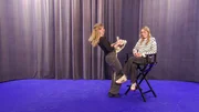 Lisa versucht Lena mit einem Steckenpferd zum Lachen zu bringen.