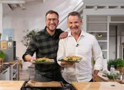 S&ouml;ren Anders (li.) ist gespannt, wie das Schweinekotelett BBQ-Style mit Pilzen und Parmesan-Spinat, das Christian Henze gekocht hat, schmecken wird.