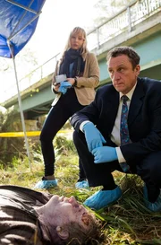 Polizeichef McLeod (Mark Clare) und Sims (Fern Sutherland) untersuchen die Leiche von Nate Dunn (Chris Sherwood). Polizeichef McLeod (Mark Clare) und Sims (Fern Sutherland) untersuchen die Leiche von Nate Dunn (Chris Sherwood).