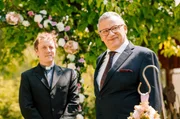 Mathias (Hannes Hellmann, re.) freut sich neben dem Pfarrer Sch&auml;fer (Jesse Albert, li.) auf seine Braut.
