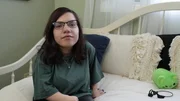 Natalia sits on her bed