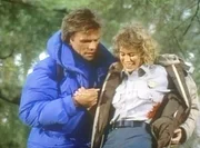MacGyver (Richard Dean Anderson, l.) hilft Karen (Moira Walley, r.), die von Wilderern angeschossen wurde. MacGyver (Richard Dean Anderson, l.) hilft Karen (Moira Walley, r.), die von Wilderern angeschossen wurde.