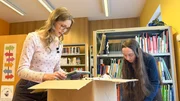 Bibliothekarin Lisa und Lena packen neue Bücher aus. Bibliothekarin Lisa und Lena packen neue Bücher aus.