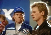 Jeff Stone (Patrick Wayne, l.) erklärt MacGyver (Richard Dean Anderson, r.), dass an seinem Auto Sabotage verübt worden ist. Jeff Stone (Patrick Wayne, l.) erklärt MacGyver (Richard Dean Anderson, r.), dass an seinem Auto Sabotage verübt worden ist.