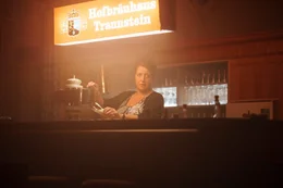 Kellnerin Gerda Bichler (Luise Kinseher) klagt, sie m&uuml;sse immer wieder dem Wirt &bdquo;zu Diensten&ldquo; sein und habe nichts davon.