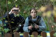 Ela (Cosima Henman) und Oscar (Oskar Keymer) haben sich auf die Lauer gelegt und beobachten durch ein Fernglas, wie Heinz den Schrebergarten erreicht.