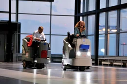 Anne (Katja Flint) und Gregor (Richy M&uuml;ller) liefern sich ausgelassen ein Rennen auf Reinigungsmaschinen in der menschenleeren Abflughalle am Flughafen.