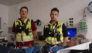 Übergabe in der Klinik: Zwei Rettungskräfte bringen einen Patienten in die Notaufnahme. Übergabe in der Klinik: Zwei Rettungskräfte bringen einen Patienten in die Notaufnahme.