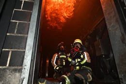 Sara und Brian von der Freiwilligen Feuerwehr G&uuml;nzburg nehmen im W&uuml;rzburger Brandhaus an einem Lehrgang f&uuml;r Atemschutzger&auml;tetr&auml;ger teil. Dort werden sogar Flashover simuliert. Brian beh&auml;lt die Flammen im Auge, w&auml;hrend Sara mit den Strahlrohr auf das Feuer zielt.
