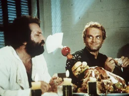 Pater J. (Terence Hill, r.) und Pater Pedro (Bud Spencer, l.) erfreuen sich lieber an den handfesten Gen&uuml;ssen des Lebens. Doch bei beiden sitzt das Herz auf dem rechten Fleck, und sie setzen sich f&uuml;r die Eingeborenen ein und helfen ihnen ...