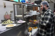 Chefkoch Mohammed Hussain bereitet die wichtigste Zutat f&uuml;r das indische Dhansak zu: den K&uuml;rbis.
